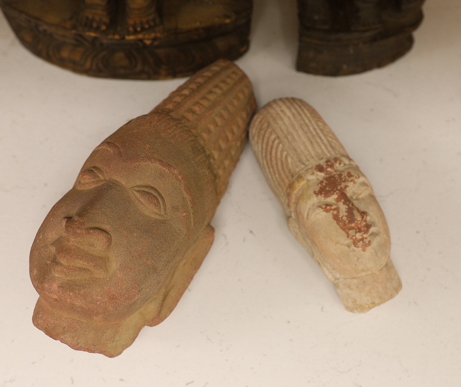 Two Indian carved stone deity heads and two Indian carved figures of Hindu deities, tallest 32cm